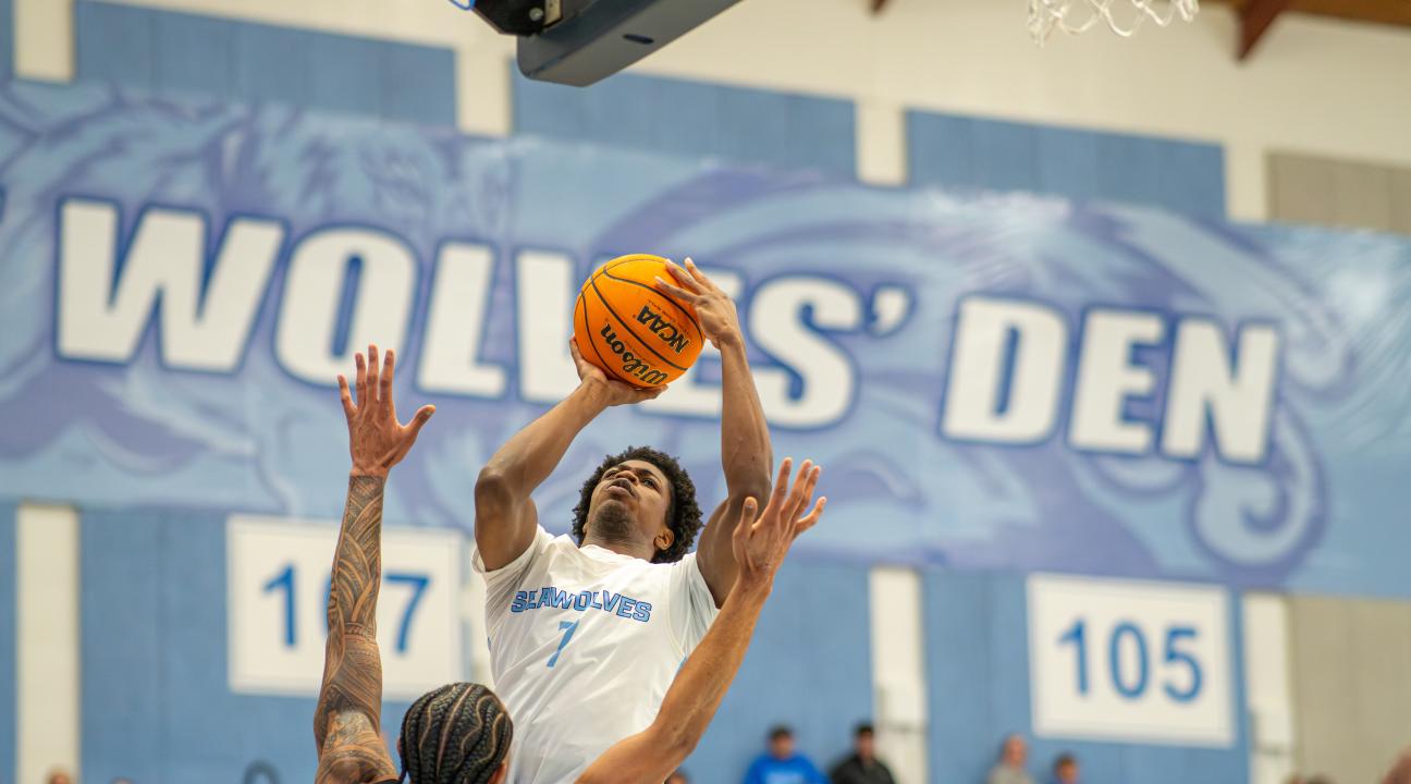 Student jumping in the air with a basketball 