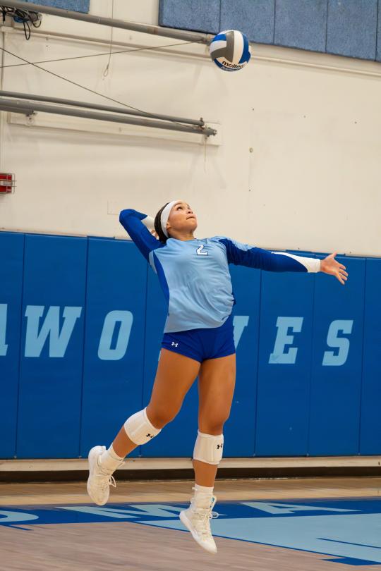 Student jumping in the air to hit a volleyball