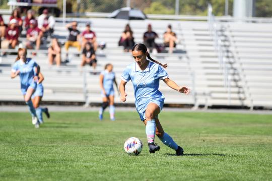 Student kicking a soccer ball